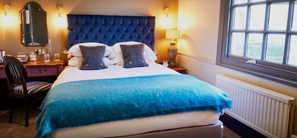 The Fleece At Cirencester Eksteriør billede A bed with a blue throw